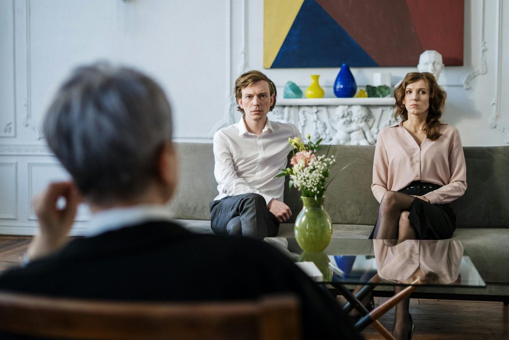 A couple consulting with a therapist in a modern studio setting.